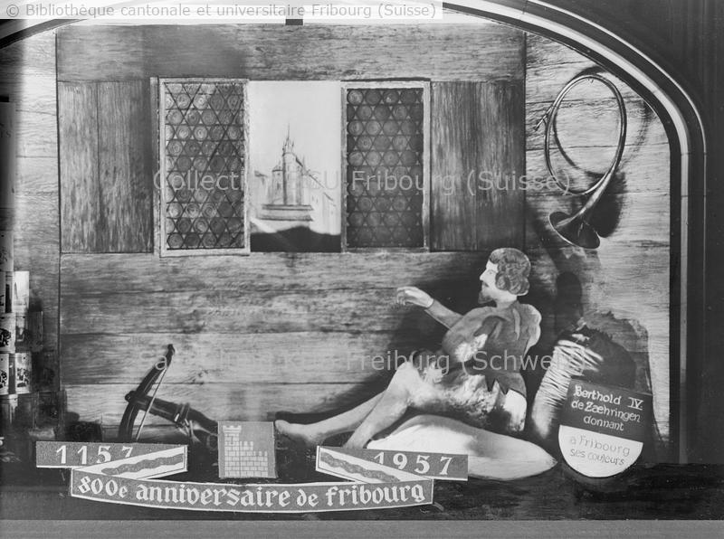 <strong>Reproduction à l'occasion du 800e (1157 à 1957) anniversaire de Fribourg A gauche de la vitrine: boîtes des Cafés torréfiés Eigenmann </strong>