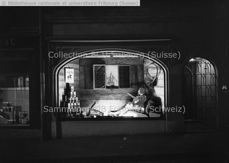 <strong>Reproduction à l'occasion du 800e (1157 à 1957) anniversaire de Fribourg A gauche de la vitrine: boîtes des Cafés torréfiés Eigenmann </strong>